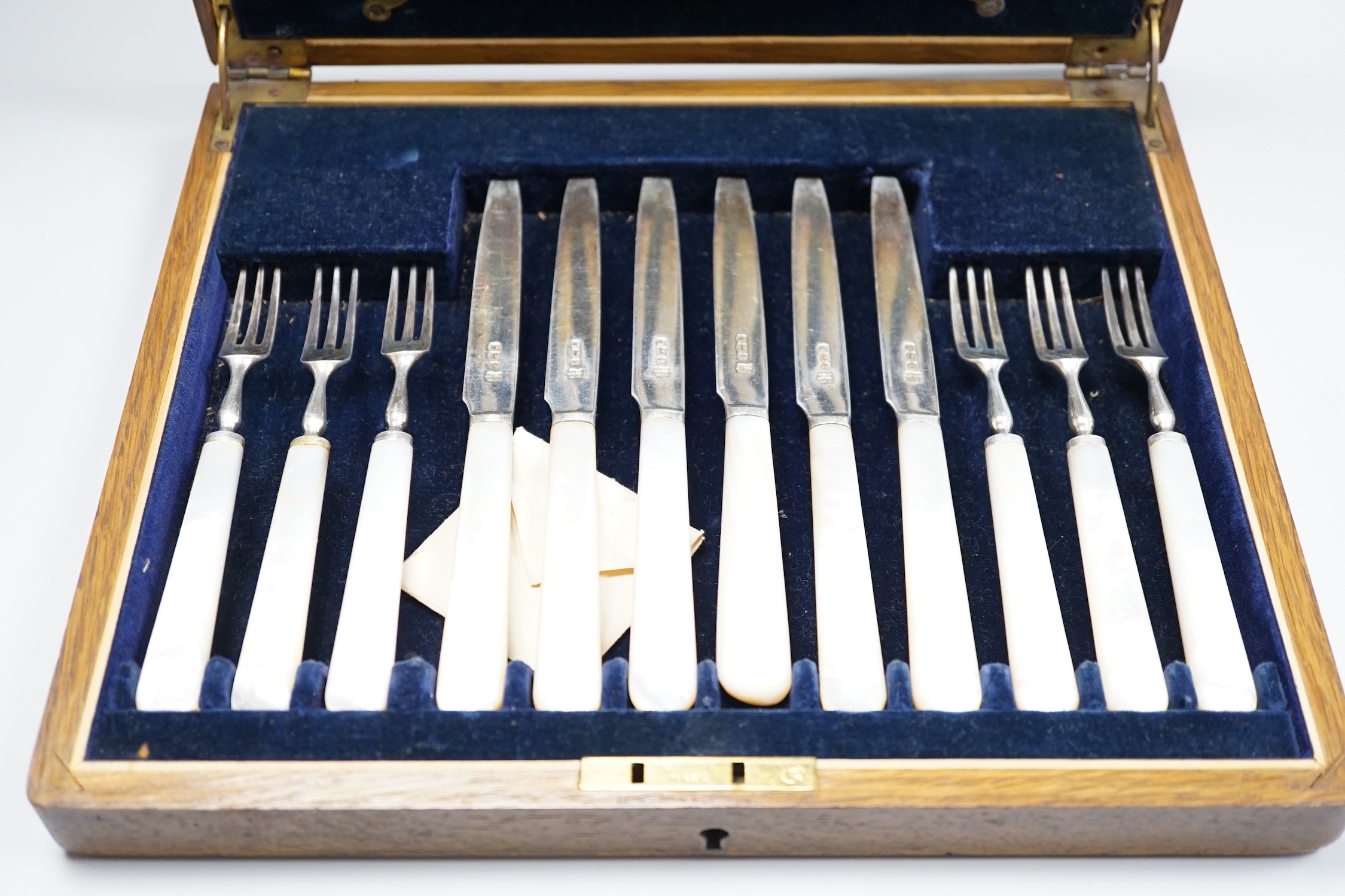 A cased set of twelve pairs of George V mother of pearl handled silver dessert eaters, Isaac Ellis & Sons, Sheffield, 1924.